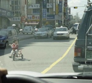NiÃ±o en un triciclo en medio de la calle